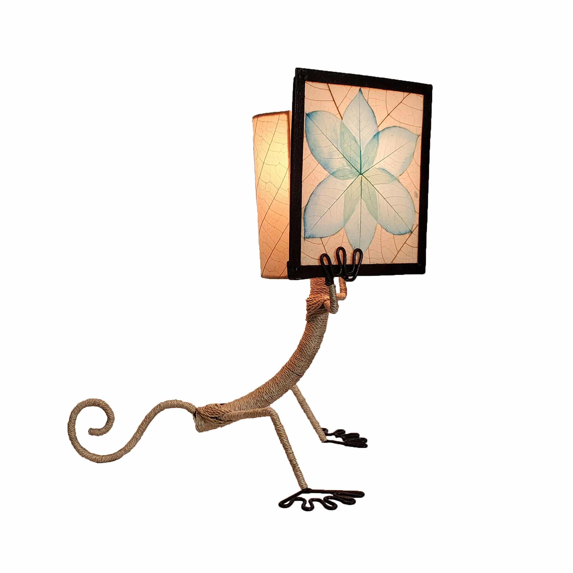 Crafted by the artisans of Eangee Home Design, the Enlightened Gecko Table Lamp in sea blue against a clean backdrop, featuring fossilized cocoa leaf shade, guyabano leaf shade, abaca rope accents, wrought iron frame, handcrafted.