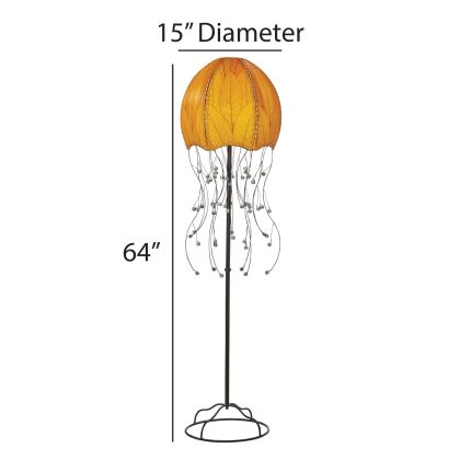 In a modern living room, the Jellyfish Large Floor crafted by the artisans of Eangee Home Design Lamp in orange finish by Eangee Home Design stands tall, its fossilized cocoa leaf panels, powder coated wrought iron frame, wrought iron frame, and hand placed natural leaves casting a warm glow that there's something hypnotic about it this lamp moves you before it ever moves.