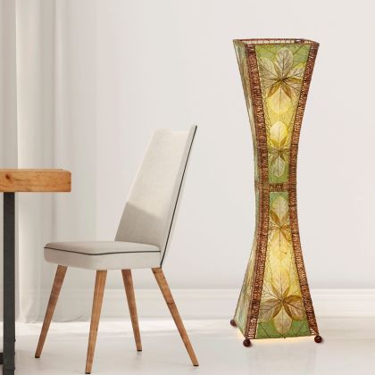 In a minimalist loft with natural textures, crafted by the artisans of Eangee Home Design, the Hourglass Large Floor Lamp in green stands gracefully, featuring jackfruit leaf panels, abaca rope accents, fair trade, eco friendly, sustainably sourced, adding warmth and character to the space.