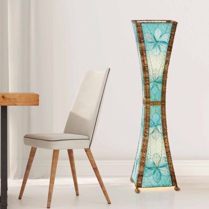 In a sun drenched entryway, crafted by the artisans of Eangee Home Design, the Hourglass Large Floor Lamp in sea blue stands gracefully, featuring jackfruit leaf panels, abaca rope accents, fair trade, eco friendly, sustainably sourced, adding warmth and character to the space.
