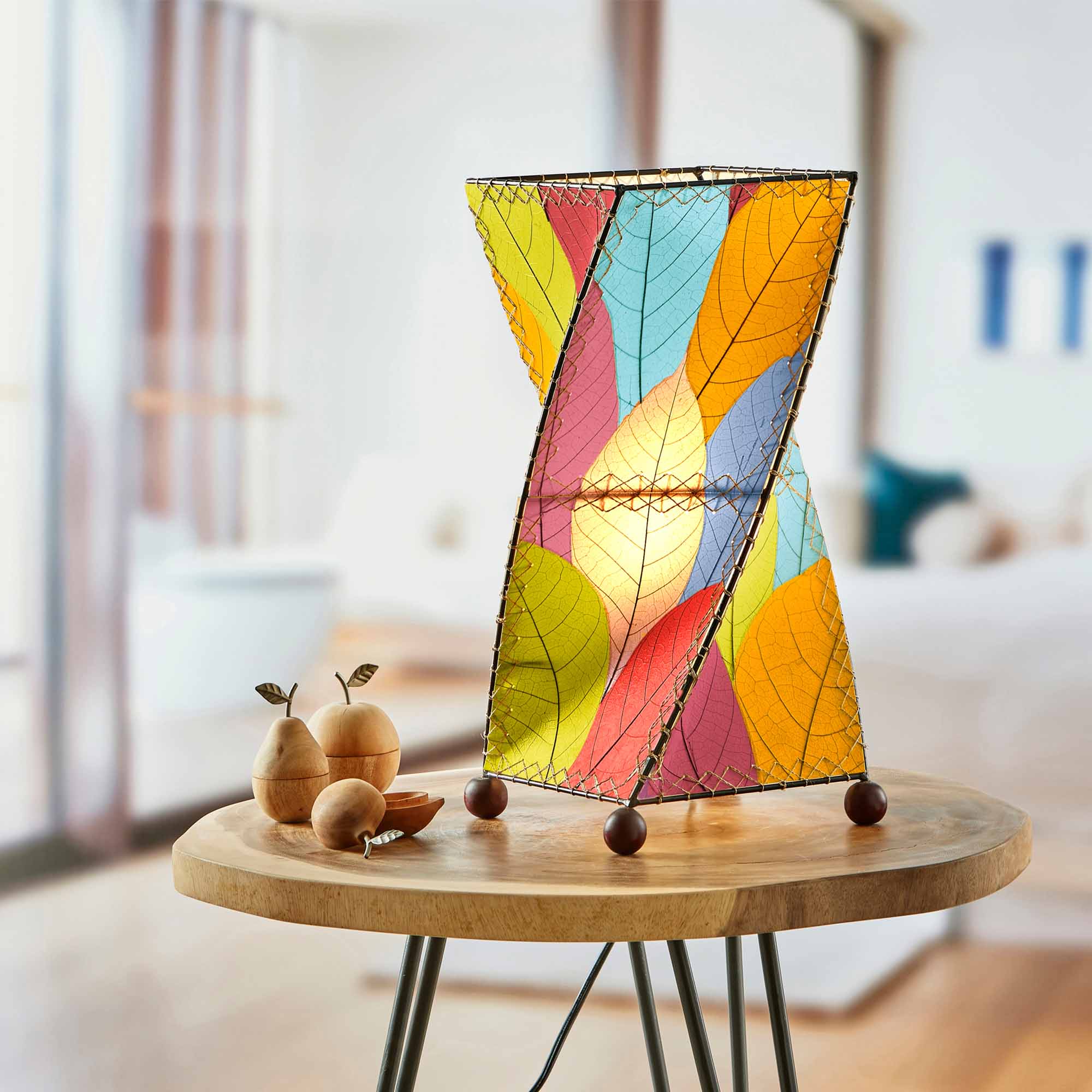 In a sun drenched entryway, crafted by the artisans of Eangee Home Design, the Twist Table Lamp in multi color stands gracefully, featuring fossilized cocoa leaf shade, wrought iron frame, handcrafted, adding warmth and character to the space.