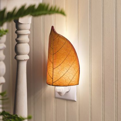 Crafted by the artisans of Eangee Home Design, the Leaf Nightlight in burgundy against a clean backdrop, featuring fossilized cocoa leaf shade, eco friendly, handcrafted.