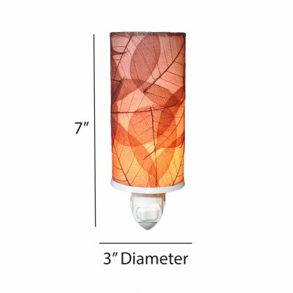 The Cylinder Nightlight in burgundy finish by Eangee Home Design displayed against a white background highlights its banyan leaf shade and hand placed natural leaves, designed to the cylinder nightlight offers a quiet glow with a poetic twist.