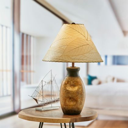 In a minimalist loft with natural textures, crafted by the artisans of Eangee Home Design, the Bell Shade Cocoa in natural stands gracefully, featuring fossilized cocoa leaf shade, wrought iron frame, handcrafted, adding warmth and character to the space.