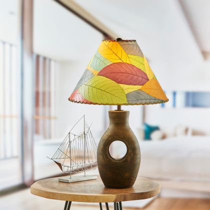 In a coastal inspired living room, crafted by the artisans of Eangee Home Design, the Bell Shade Cocoa in multi color stands gracefully, featuring fossilized cocoa leaf shade, wrought iron frame, handcrafted, adding warmth and character to the space.