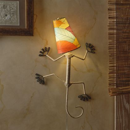 In a minimalist loft with natural textures, crafted by the artisans of Eangee Home Design, the Gecko Wall Lamp Shade in multi color hangs, featuring fossilized cocoa leaf shade, abaca rope accents, wrought iron frame, handcrafted, adding warmth and character to the space.