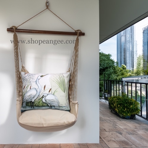 In a sunlit patio lounge a multi colored outdoor swing crafted by the artisans of Magnolia Casual called the Swing Set 4 piece Latte Solid w/ Heron Pair is displayed featuring 100 percent weather resistant fabric, weather resistant polyester fabric, handcrafted adding comfort and style to the space.