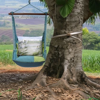 In a sunlit patio lounge a multi colored outdoor swing crafted by the artisans of Magnolia Casual called the Swing Set 4 piece Meadow Mist Stripe w/ Seagulls is displayed featuring 100 percent weather resistant fabric, weather resistant polyester fabric, handcrafted, natural materials adding comfort and style to the space featuring with a stripe motif.