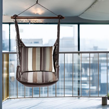 In a cozy garden seating area a gray outdoor swing crafted by the artisans of Magnolia Casual called the Swing Set 4 piece Slate Gray Stripe w/ Slate Gray Stripe is displayed featuring 100 percent weather resistant fabric, weather resistant polyester fabric, handcrafted adding comfort and style to the space featuring with a stripe motif and shades of gray.