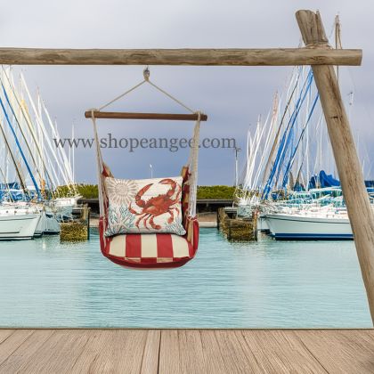 In an outdoor reading nook a multi colored outdoor swing crafted by the artisans of Magnolia Casual called the Swing Set 4 piece Americana Stripe w/ Crab with Corals is displayed featuring 100 percent weather resistant fabric, weather resistant polyester fabric, handcrafted adding comfort and style to the space featuring with a stripe motif.