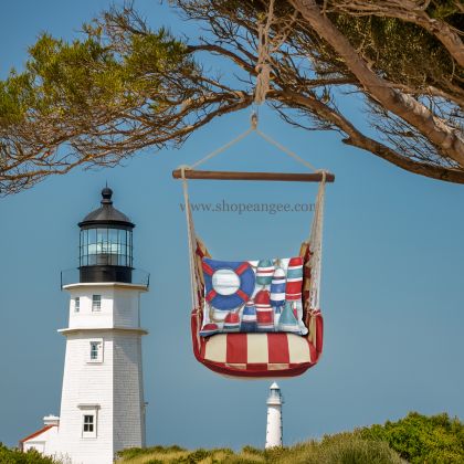 In an outdoor reading nook a red outdoor swing crafted by the artisans of Magnolia Casual called the Swing Set 4 piece Americana Stripe w/ Red and Blue Buoys is displayed featuring 100 percent weather resistant fabric, weather resistant polyester fabric, handcrafted adding comfort and style to the space featuring with a stripe motif and shades of red and blue.