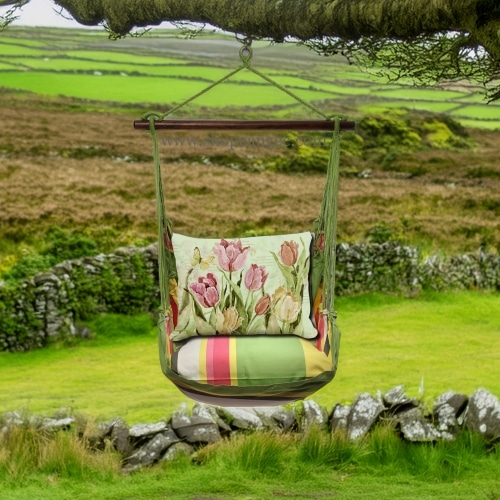 In an outdoor reading nook a pink outdoor swing crafted by the artisans of Magnolia Casual called the Swing Set 4 piece Fresh Lime Stripe w/ Pink and Yellow Tulips is displayed featuring 100 percent weather resistant fabric, weather resistant polyester fabric, handcrafted adding comfort and style to the space featuring with a stripe motif and shades of lime, pink and yellow.