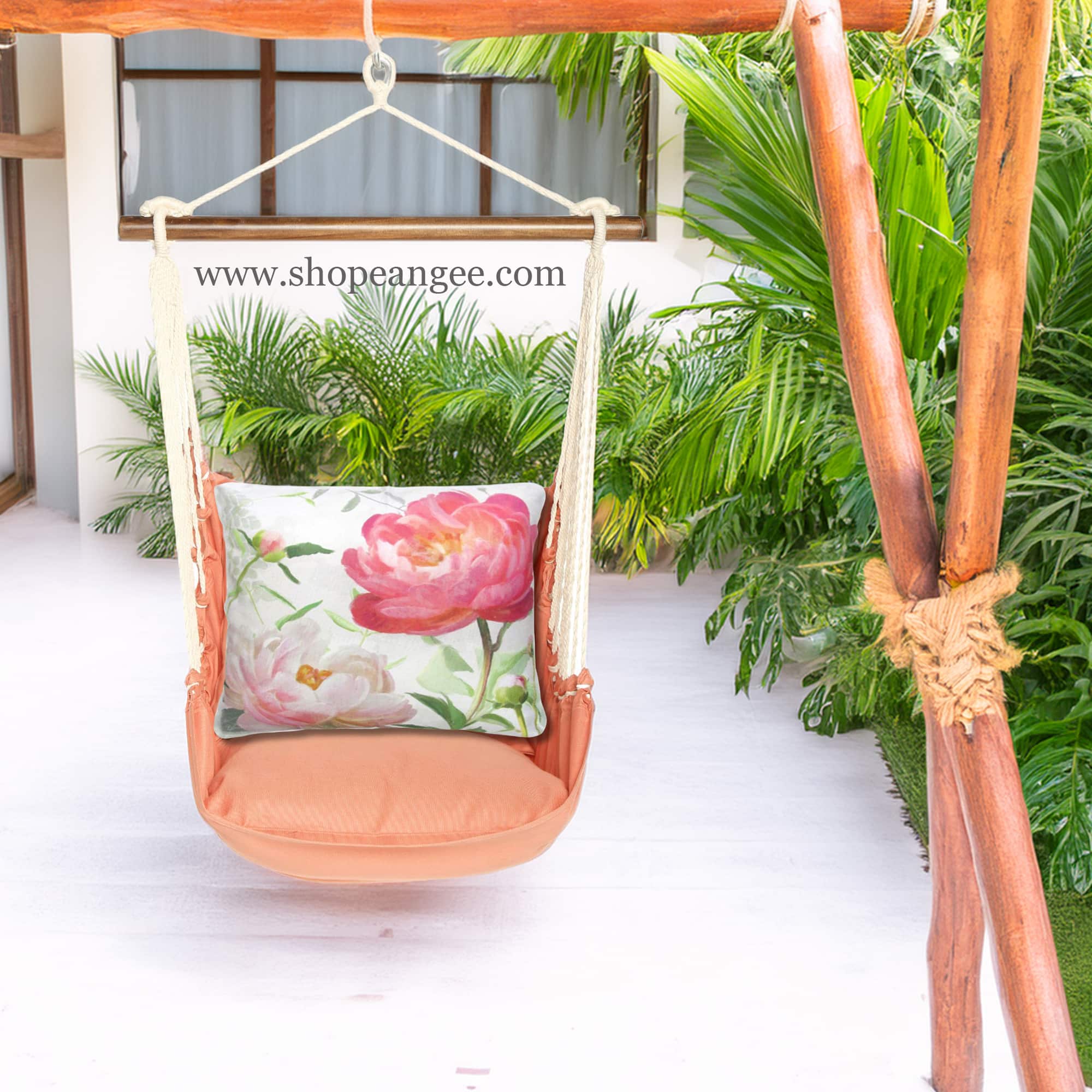 In an outdoor reading nook a multi colored outdoor swing crafted by the artisans of Magnolia Casual called the Swing Set 4 piece Living Coral w/ Peony 2 is displayed featuring 100 percent weather resistant fabric, weather resistant polyester fabric, handcrafted adding comfort and style to the space featuring with a coral motif and shades of coral.