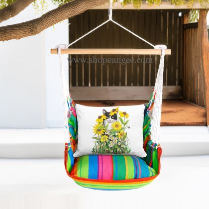 In a shaded porch swing a multi colored outdoor swing crafted by the artisans of Magnolia Casual called the Swing Set 4 piece Le Jardin Nouveau w/ Cat with Daisies is displayed featuring 100 percent weather resistant fabric, weather resistant polyester fabric, handcrafted adding comfort and style to the space featuring with a cat motif.