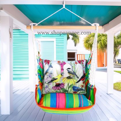 In a sunlit patio lounge a multi colored outdoor swing crafted by the artisans of Magnolia Casual called the Swing Set 4 piece Le Jardin Nouveau w/ Bird's Song is displayed featuring 100 percent weather resistant fabric, weather resistant polyester fabric, handcrafted adding comfort and style to the space featuring with a bird motif.