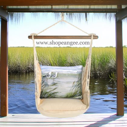 In a cozy garden seating area a multi colored outdoor swing crafted by the artisans of Magnolia Casual called the Swing Set 4 piece Magnolia Stripe w/ Seagulls is displayed featuring 100 percent weather resistant fabric, weather resistant polyester fabric, handcrafted adding comfort and style to the space featuring with a magnolia motif.