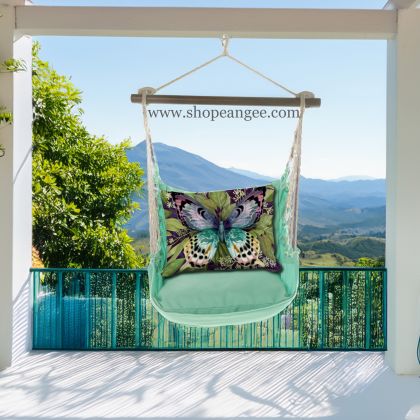 In a shaded porch swing a green outdoor swing crafted by the artisans of Magnolia Casual called the Swing Set 4 piece Seafoam Green Solid w/ Mystic Butterfly is displayed featuring 100 percent weather resistant fabric, weather resistant polyester fabric, handcrafted adding comfort and style to the space featuring with a butterfly motif and shades of green.