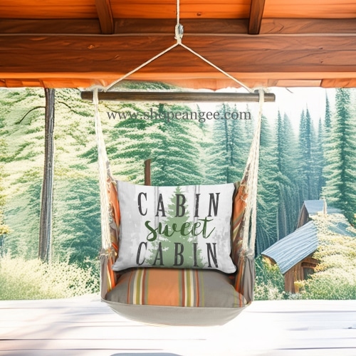 In a cozy garden seating area a multi colored outdoor swing crafted by the artisans of Magnolia Casual called the Swing Set 4 piece Serene Sunset w/ Cabin Sweet Cabin is displayed featuring 100 percent weather resistant fabric, weather resistant polyester fabric, handcrafted adding comfort and style to the space.