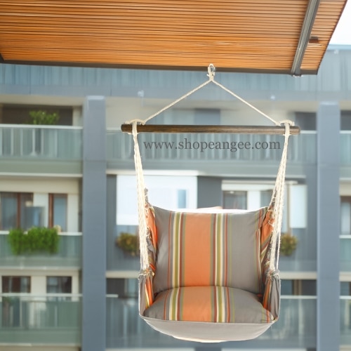 In a cozy garden seating area a multi colored outdoor swing crafted by the artisans of Magnolia Casual called the Swing Set 4 piece Serene Sunset w/ Serene Sunset is displayed featuring 100 percent weather resistant fabric, weather resistant polyester fabric, handcrafted adding comfort and style to the space.