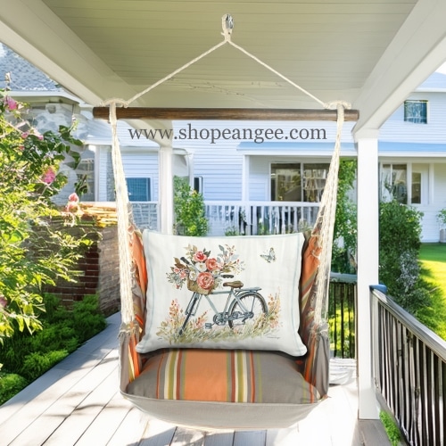 In a sunlit patio lounge a multi colored outdoor swing crafted by the artisans of Magnolia Casual called the Swing Set 4 piece Serene Sunset w/ Bike with Flower Basket is displayed featuring 100 percent weather resistant fabric, weather resistant polyester fabric, handcrafted adding comfort and style to the space featuring with a floral motif.