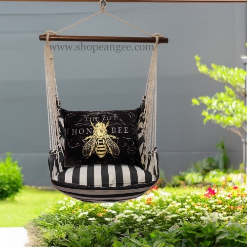 In an outdoor reading nook a black outdoor swing crafted by the artisans of Magnolia Casual called the Swing Set 4 piece True Black Stripe w/ Vintage Bee on Black is displayed featuring 100 percent weather resistant fabric, weather resistant polyester fabric, handcrafted adding comfort and style to the space featuring with a stripe motif and shades of black.