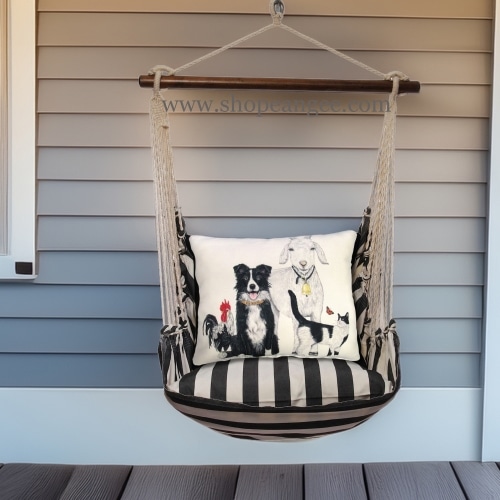 In an outdoor reading nook a black outdoor swing crafted by the artisans of Magnolia Casual called the Swing Set 4 piece True Black Stripe w/ Dog and Farm Animals is displayed featuring 100 percent weather resistant fabric, weather resistant polyester fabric, handcrafted adding comfort and style to the space featuring with a stripe motif and shades of black.