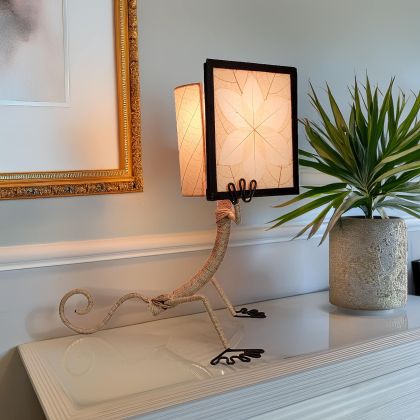 Gecko?shaped table lamp crafted by Eangee Home Design with natural fossilized cocoa?leaf panels hand?stitched onto a wrought?iron frame; playful gecko silhouette hugs the shade, and inviting light shines through every vein; artisan?made with renewable materials