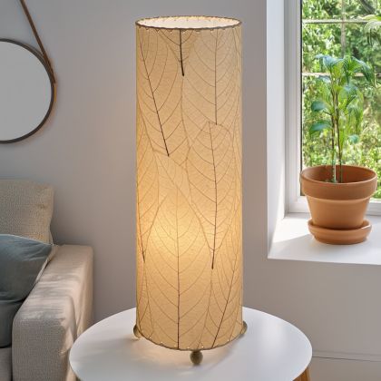 Slim cylinder table lamp crafted by Eangee Home Design in natural fossilized cocoa leaves, each panel hand?laminated and stitched; minimalist form offers textural leaf detail while glowing light filters against the leaf?veined surface; fair?trade craftsmanship using sustainable resources