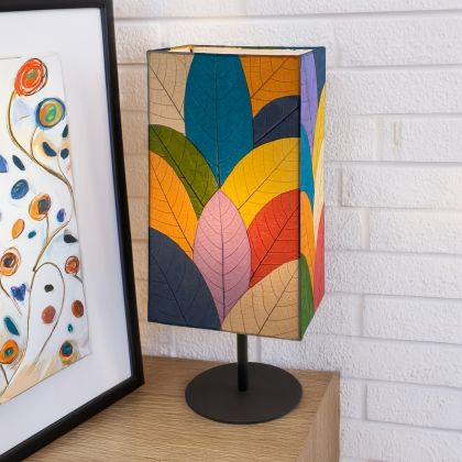 In a modern interior with earth tones, crafted by the artisans of Eangee Home Design, the Sequoia Table Lamp in multi color stands gracefully, featuring fossilized cocoa leaf shade, fair trade, sustainably sourced, adding warmth and character to the space.