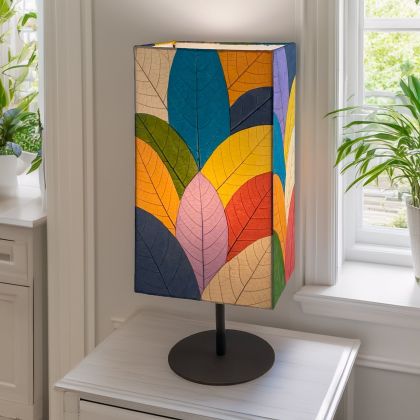Tall Sequoia?inspired table lamp crafted by Eangee Home Design clad in multi color fossilized cocoa leaves on a curved wrought?iron frame; towering form echoes tree bark texture, and cozy light shines through every vein; artisan?made with renewable materials