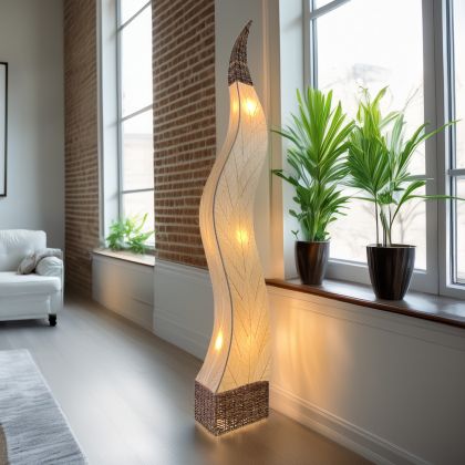 In a coastal inspired living room, crafted by the artisans of Eangee Home Design, the Flame Giant Lamp in natural stands gracefully, featuring fossilized cocoa leaf shade, abaca rope accents, fair trade, adding warmth and character to the space.