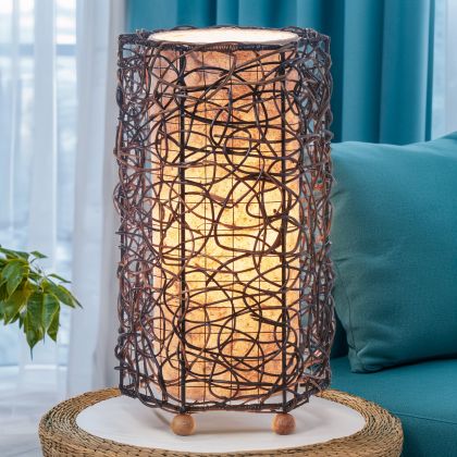 Nito?vine table lamp crafted by Eangee Home Design with natural leaf diffuser; hand?woven natural fibers cast patterned shadows as ambient light shines through translucent cocoa leaves; artisan?made from sustainable materials