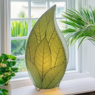 Leaf?shaped Leaflet table lamp crafted by Eangee Home Design with green fossilized cocoa leaves stitched by hand to wrought iron; budding?leaf form breathes life as cozy light glows through the natural leaf veins; fair?trade craftsmanship using sustainable resources