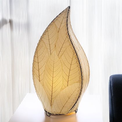In a coastal inspired living room, crafted by the artisans of Eangee Home Design, the 24 Inch Leaflet Lamp in natural stands gracefully, featuring fossilized cocoa leaf shade, abaca rope accents, wrought iron frame, handcrafted, adding warmth and character to the space.