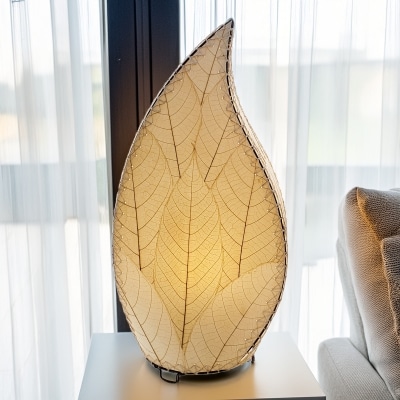 In a sun drenched entryway, crafted by the artisans of Eangee Home Design, the 24 Inch Leaflet Lamp in natural stands gracefully, featuring fossilized cocoa leaf shade, abaca rope accents, wrought iron frame, handcrafted, adding warmth and character to the space.