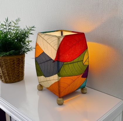 Crafted by the artisans of Eangee Home Design, the Mini Square Cocoa Leaf Table Lamp in multi color against a clean backdrop, featuring fossilized cocoa leaf shade, wrought iron frame, fair trade, eco friendly, sustainably sourced, handcrafted.