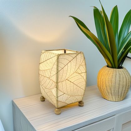 Crafted by the artisans of Eangee Home Design, the Mini Square Cocoa Leaf Table Lamp in natural against a clean backdrop, featuring fossilized cocoa leaf shade, wrought iron frame, fair trade, eco friendly, sustainably sourced, handcrafted.