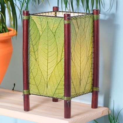 Square Fortune series table lamp crafted by Eangee Home Design wrapped in green fossilized cocoa leaves, abaca?stitched edges, rattan legs; geometric lines softened as warm light filters through every vein; sustainably handcrafted by skilled artisans