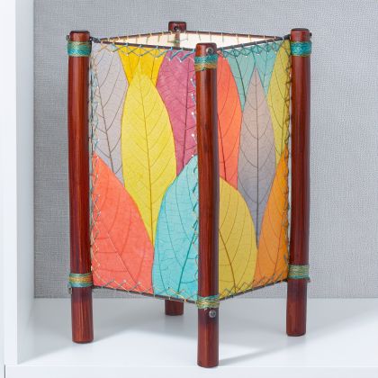 In a modern interior with earth tones, crafted by the artisans of Eangee Home Design, the Fortune Table Lamp in multi color stands gracefully, featuring fossilized cocoa leaf shade, abaca rope accents, rattan leg supports, adding warmth and character to the space.
