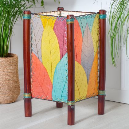 Square Fortune series table lamp crafted by Eangee Home Design wrapped in multi color fossilized cocoa leaves, abaca?stitched edges, rattan legs; geometric lines softened as ambient light radiates through organic leaf texture; handcrafted sustainably by fair?trade artisans