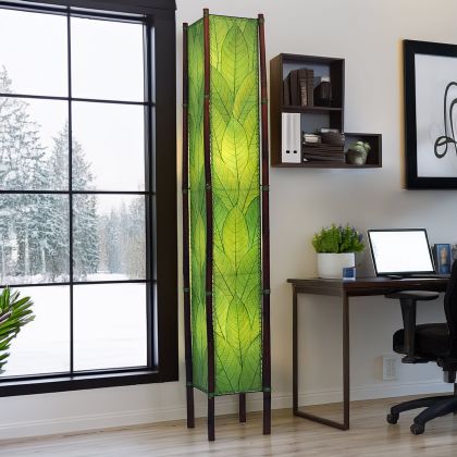 In a softly lit reading nook, crafted by the artisans of Eangee Home Design, the Fortune Giant Floor Lamp in green stands gracefully, featuring fossilized cocoa leaf shade, abaca rope accents, rattan leg supports, wrought iron frame, eco friendly, adding warmth and character to the space.