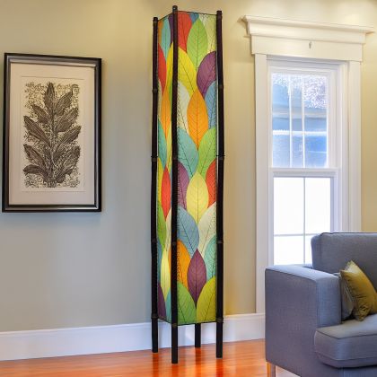 In a modern living room, the Fortune Giant Floor crafted by the artisans of Eangee Home Design Lamp in multi color finish by Eangee Home Design stands tall, its fossilized cocoa leaf panels, abaca twine accents, rattan legs, powder coated wrought iron frame, wrought iron frame, hand placed natural leaves, hand placed leaf panels, and abaca twine stitching casting a warm glow that some pieces don't just fill a space they define it.
