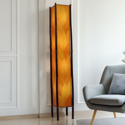 In a modern interior with earth tones, crafted by the artisans of Eangee Home Design, the Fortune Giant Floor Lamp in orange stands gracefully, featuring fossilized cocoa leaf shade, abaca rope accents, rattan leg supports, wrought iron frame, eco friendly, adding warmth and character to the space.