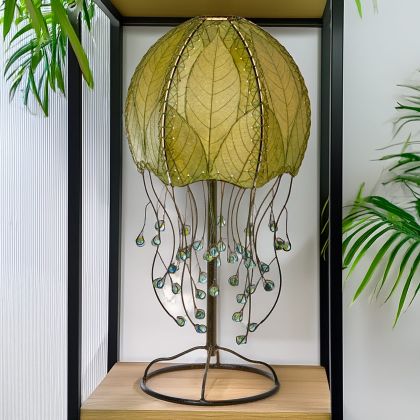 Jellyfish?inspired table lamp crafted by Eangee Home Design draped in green cocoa?leaf panels that flow like tentacles; underwater feel enhanced as ambient light shines across the textured leaf panels; eco?friendly, artisan?crafted design