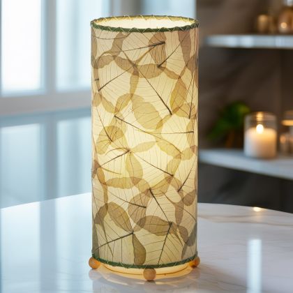 Banyan?inspired table lamp crafted by Eangee Home Design woven with green fossilized cocoa leaves between wrought?iron ribs; branching silhouette highlights leaf texture while cozy light spills through the natural leaf veins; handcrafted sustainably by fair?trade artisans