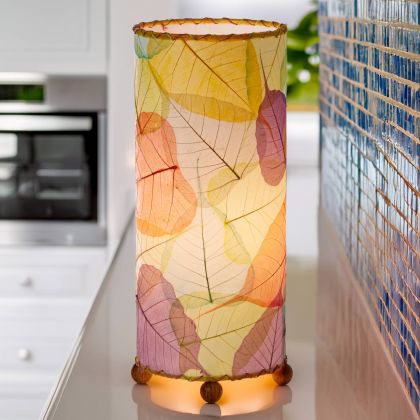 Banyan?inspired table lamp crafted by Eangee Home Design woven with multi color fossilized cocoa leaves between wrought?iron ribs; branching silhouette highlights leaf texture while cozy light shines across the textured leaf panels; fair?trade craftsmanship using sustainable resources