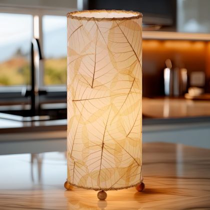 In a softly lit reading nook, crafted by the artisans of Eangee Home Design, the Banyan Table Lamp in natural stands gracefully, featuring wrought iron frame, eco friendly, adding warmth and character to the space.