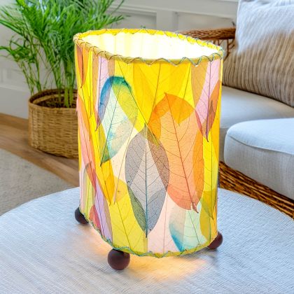 Crafted by the artisans of Eangee Home Design, the Mini Guyabano Table Lamp in multi color against a clean backdrop, featuring fossilized cocoa leaf shade, guyabano leaf shade, wrought iron frame.