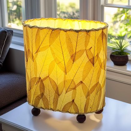 Crafted by the artisans of Eangee Home Design, the Mini Guyabano Table Lamp in natural against a clean backdrop, featuring fossilized cocoa leaf shade, guyabano leaf shade, wrought iron frame.