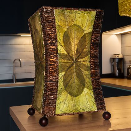 In a coastal inspired living room, crafted by the artisans of Eangee Home Design, the Hourglass Table Lamp in green stands gracefully, featuring jackfruit leaf panels, abaca rope accents, wrought iron frame, eco friendly, adding warmth and character to the space.
